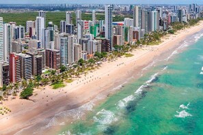 A coastal cityscape with high-rise buildings, a sandy beach, and a clear blue sea. - Apartment (Jaboatão dos Guararapes)