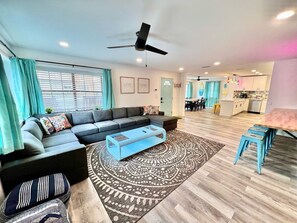 Relax in this spacious living room with a large sofa, coffee table, and dining area.