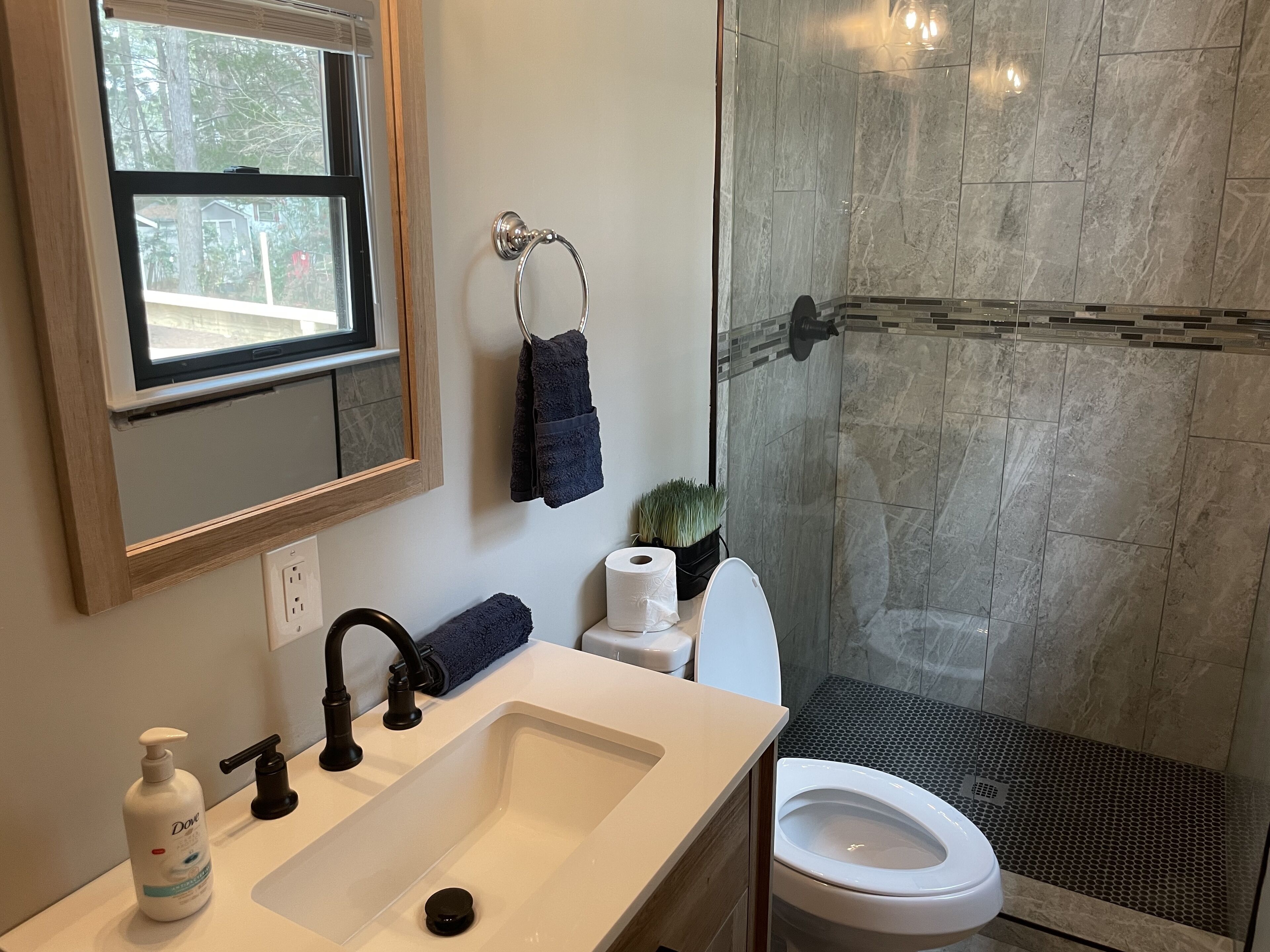 A bathroom with a sink, toilet, and shower.