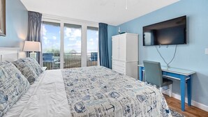 Un dormitorio con cama, escritorio, televisor y armario.