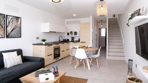 Un appartement moderne comprenant une cuisine, un coin repas et un salon.