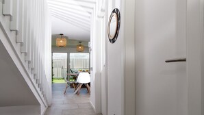 Un couloir avec un escalier menant à une salle à manger.