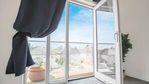 A room with a sliding glass door leading to a balcony. - Duplex Apartment • Balcony • FreeParking • SmartTV (Newport Pagnell)