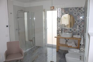 Um banheiro moderno com box de vidro, pia com espelho e vaso sanitário.
