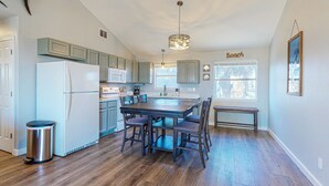A kitchen with a central island, wooden flooring, and light blue cabinets. - Room for Boat, Pet Friendly, Close to Community Pool (Port Aransas)