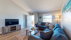 A living room with a TV, sofa, and coffee table. - Room for Boat, Pet Friendly, Close to Community Pool (Port Aransas)