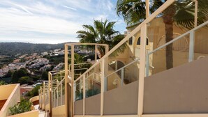 Un escalier menant à un balcon d’où l’on peut admirer une ville côtière.