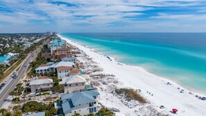 A coastal hotel with multiple buildings, a beach, and a clear view of the ocean.
