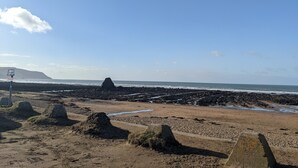 A beach with rocky formations and a clear sky.