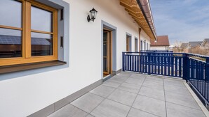 Ein Gebäude mit Balkon, blauem Zaun und einer Tür.