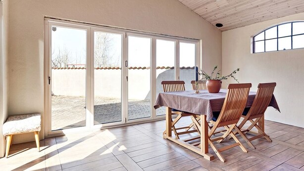 A dining area with a table set for four, wooden chairs, and a potted plant. - Fantastic Villa in the Countryside - 20 Mins From Malmo (Svedala)