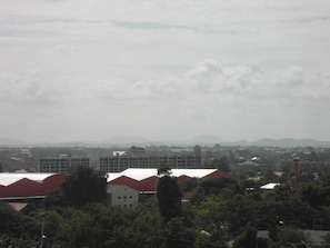 A view of a residential area with houses and buildings, including a large structure with a red roof and a smaller building with a white roof.