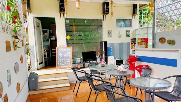 A café with round tables and chairs, a chalkboard menu, and a view of the outdoors. - Comfortable Room With Ac and Wifi for 2 People (Bogor)