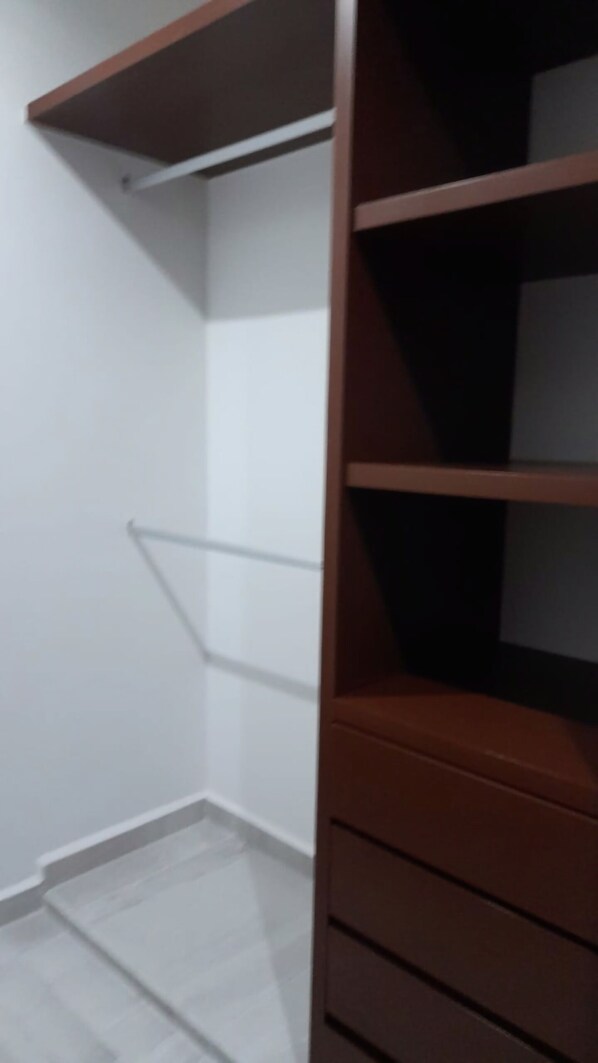 A room with a wooden wardrobe and a white wall.