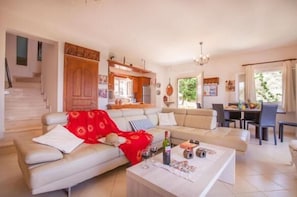 A modern living room with a sofa, coffee table, and dining area. - Villa Elissavet - Kalami Bay - Family Pool House (Corfu)