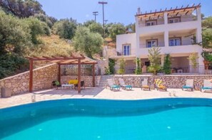 A two-story building with a swimming pool, outdoor seating, and a stone wall. - Villa Elissavet - Kalami Bay - Family Pool House (Corfu)