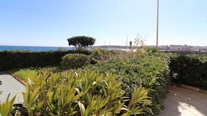 Ein angelegter Garten mit einem Weg, der zum Blick auf das Meer führt.