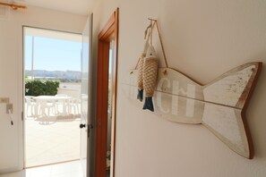 A fish-shaped wall decoration with a door leading to an outdoor seating area. - Travellito Vacanze House Benny Otranto (Otranto)