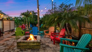 A patio area with a fire pit, outdoor seating, and a view of the sky.