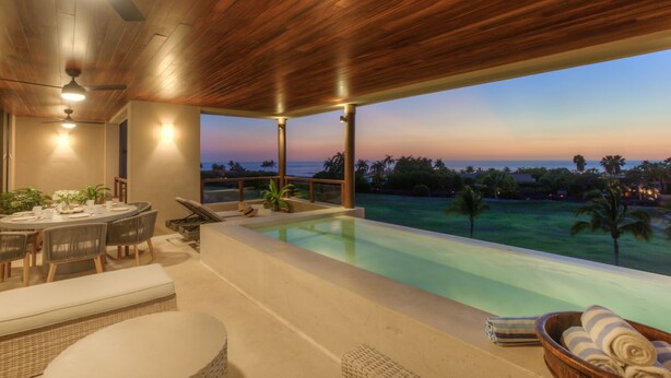 Area piscina moderna all'aperto con vista tramonto, soffitto in legno e zona relax con divani.