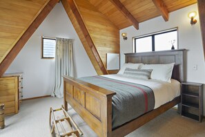 A bedroom with a wooden bed, a nightstand, a dresser, and a window with curtains. - Snow Chalet - Fairlie Holiday Home (Fairlie)