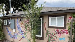 A building with a textured wall, a window, and a door. - Centrally located 1 bd/1ba bungalow (Missoula)