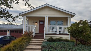 Eingeschossiges Haus mit Veranda, rotem Tür und Briefkasten.