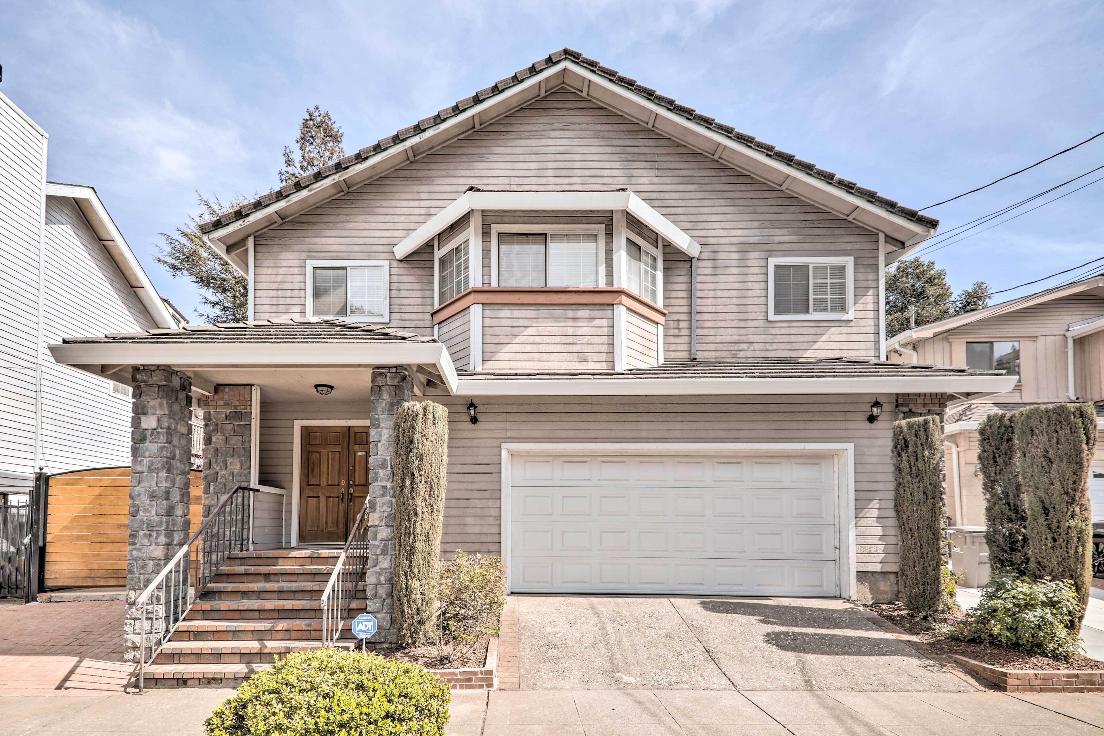 A two-story house with a front porch, a garage, and a stone pillar.