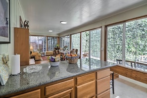Una cocina amplia con ventanas grandes, armarios de madera y encimera de granito.