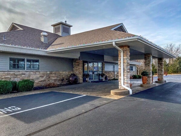 A building with a covered entrance, stone facade, and a parking lot. - Pool | WiFi | Lake Views| Sleeps 8 | Lake (493DC) (Village of Four Seasons)