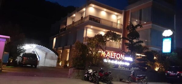A multi-story hotel with a prominent sign, a covered entrance, and several parked motorcycles. - Kalton Hotel Labuan Bajo (Labuan Bajo)