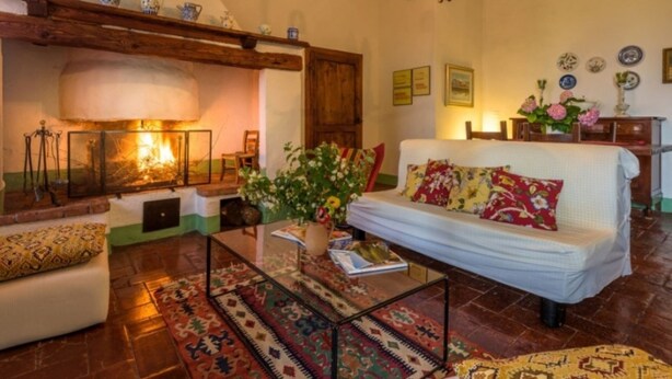Una sala de estar acogedora con chimenea, un sofá y una mesa de centro.