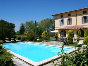 A swimming pool with lounge chairs and a patio area with tables and chairs. - Large Villa for 15 guests. Private pool. Trasimeno Lake (Castiglione del Lago)