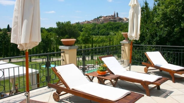 A terrace with wooden lounge chairs, white cushions, and beige umbrellas. - Villa Del Portico. AC, Private pool. Pets allowed (Castiglion Fiorentino)