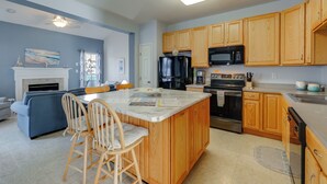 A modern kitchen with wooden cabinets, a central island, and a built-in oven. - < 3 Mi to Bethany Beach: Family Gem w/ Game Room (Millville)