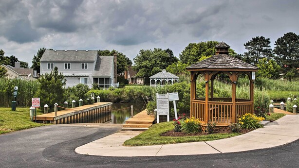 A gazebo with a wooden roof and a signboard, a wooden dock over water, and houses in the background. - < 3 Mi to Bethany Beach: Family Gem w/ Game Room (Millville)