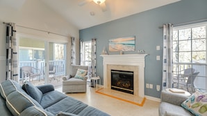 A spacious living room with a fireplace, a large sofa, and a dining area with outdoor seating. - < 3 Mi to Bethany Beach: Family Gem w/ Game Room (Millville)