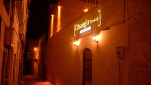 Uma passagem estreita com um edifício exibindo uma placa com os dizeres "Cihangir Konak" e "Butik Otel".