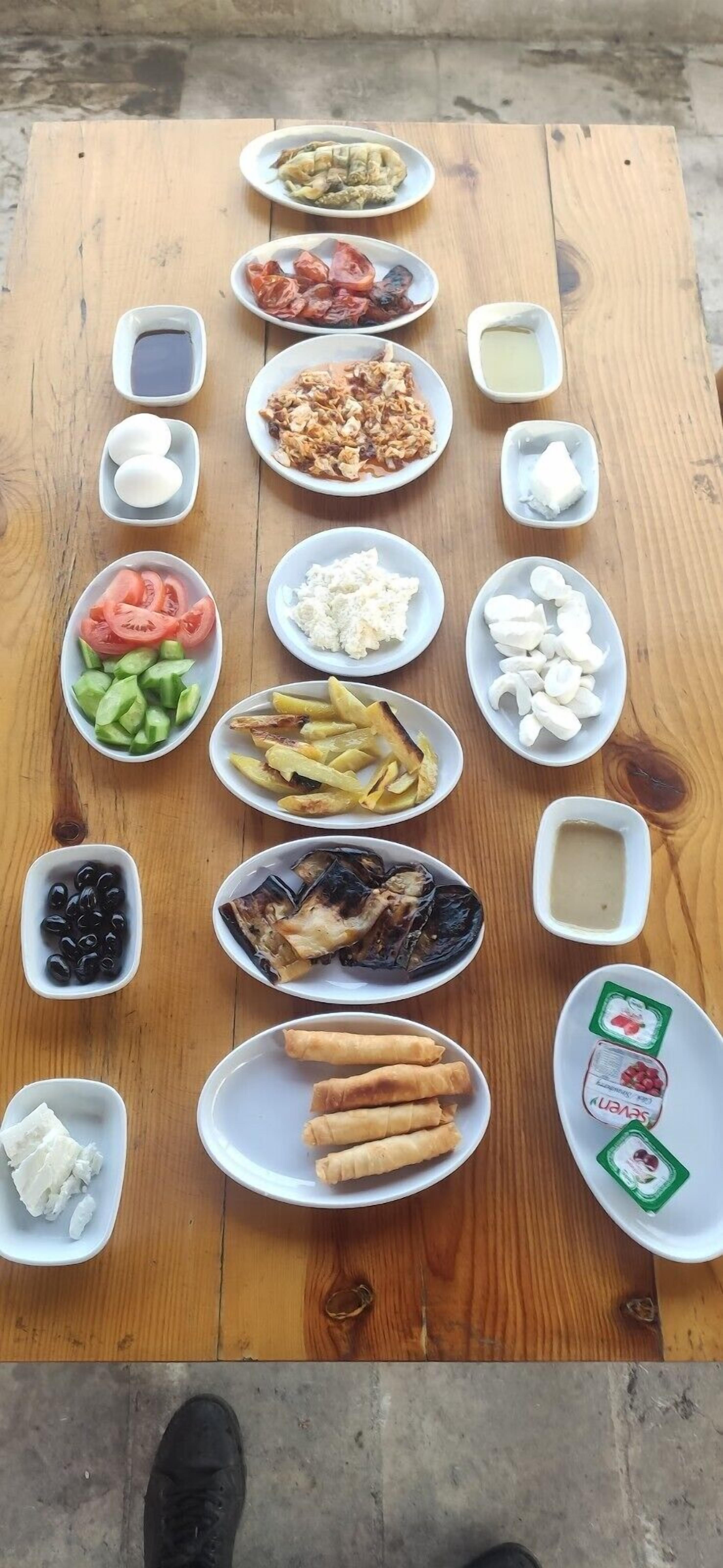 A wooden table with various dishes and condiments.