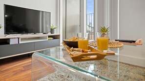 Relax in this comfortable living space with a flat-screen TV, entertainment unit, and large window.