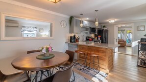 A modern kitchen with a central island, bar stools, and pendant lighting. - DT Bar Harbor,2 King beds & Decks, Parks 3 small cars, Town Pickleball Ct @ Back (Bar Harbor)