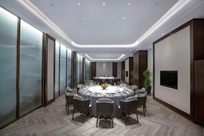 A conference room with a round table, chairs, a television, and a large window. - Holiday Inn Taiyuan City Center (Taiyuan)