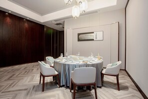 A conference room with a round table, white chairs, and a chandelier. - Holiday Inn Taiyuan City Center (Taiyuan)