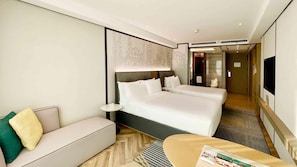 A hotel room with a large bed, a sofa, a small table, and a TV. - Holiday Inn Taiyuan City Center (Taiyuan)