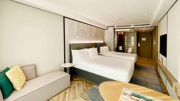 A hotel room with a large bed, a sofa, a small table, and a TV. - Holiday Inn Taiyuan City Center (Taiyuan)