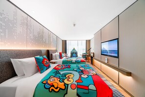 Una habitación de hotel con una cama grande, televisión y vista panorámica de la ciudad.