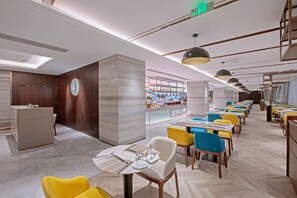 A modern hotel lobby with a reception desk, seating area, and a bar. - Holiday Inn Taiyuan City Center (Taiyuan)