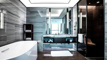 A modern bathroom with a freestanding bathtub, a glass-enclosed shower, and a large mirror.