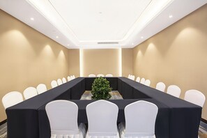 A conference room with a long table, white chairs, and a small plant. - Holiday Inn Taiyuan City Center (Taiyuan)