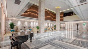A spacious lobby with marble flooring, a grand piano, and modern furnishings. - Holiday Inn Taiyuan City Center (Taiyuan)